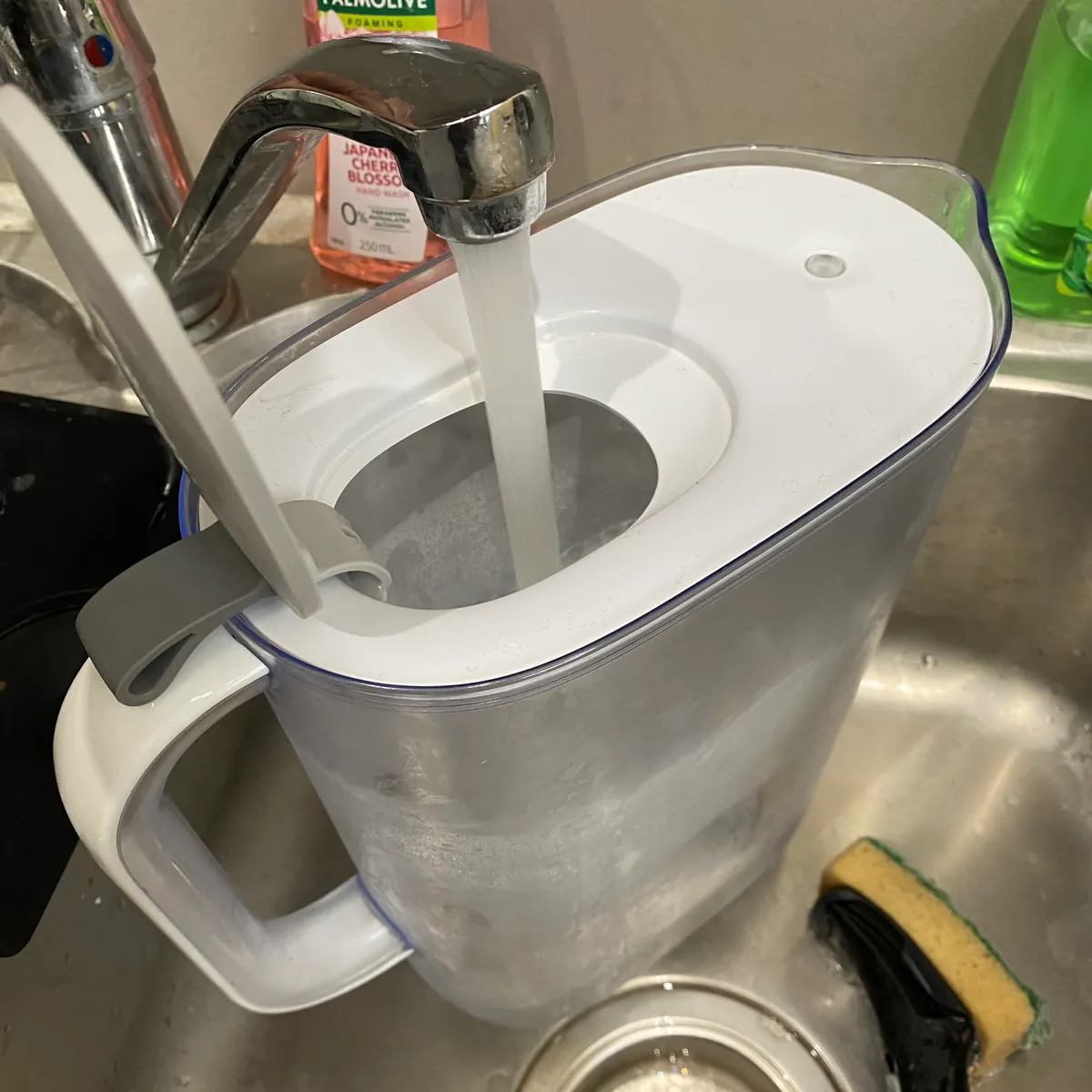 Pouring water into Brita Style water filter. Inner lid holds itself up for easy pouring with minimal effort.